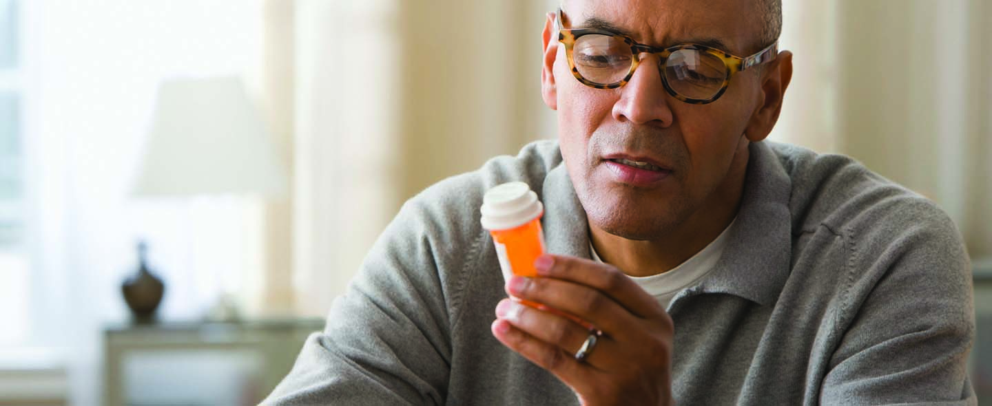 Man looking at orange bottle